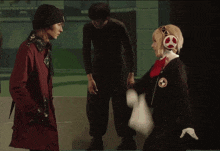 a man in a black suit holds a piece of paper in front of a woman in a costume