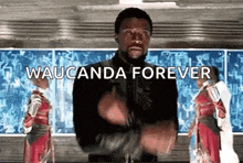 a man in a black jacket is standing in front of a chalkboard with the words waucunda forever written on it .
