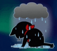 a black cat with a red bow is laying in the rain