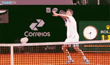 a man is playing tennis on a court with a correios logo in the background