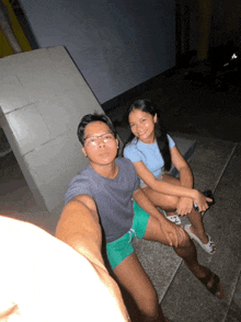 a man and a woman are posing for a picture on a sidewalk
