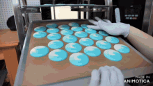 a bunch of blue and white circles are on a tray that says made in animatica