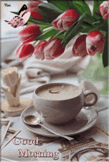 a cup of coffee sits on a saucer next to a bouquet of flowers with the words good morning written on it