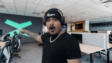 a man wearing headphones and a beanie that says rizzard is pointing