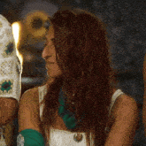 a woman with red hair is wearing a white top and green gloves