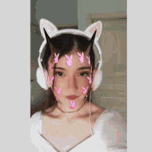 a girl wearing cat ears and headphones with pink bunny face paint