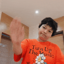 a person wearing a red shirt that says turn up the music