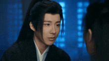 a young man with long hair is looking at a woman in a kimono .