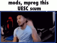 a man is sitting in front of a screen with the words mods , mpreg this uesc scum