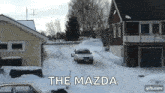 a car is driving down a snowy road with the words the mazda written on the bottom