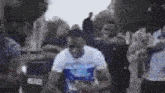 a man is standing in front of a crowd of people in a blurry photo .