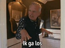 a man making a funny face in front of a mirror with the words ik ga los written on the bottom