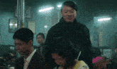a man in a black jacket is standing next to a woman