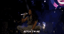 a woman is kneeling down on a stage and saying bitch i 'm me .