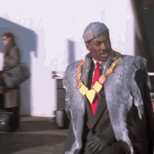 a man wearing a fur coat and a necklace