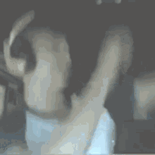 a blurry picture of a person wearing headphones and a white shirt .