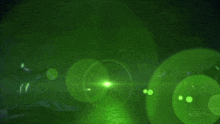 a green light is shining on a dark surface