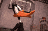 daffy duck is sitting on a bench in front of a basketball hoop .