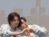 two young men are making a heart shape with their fingers