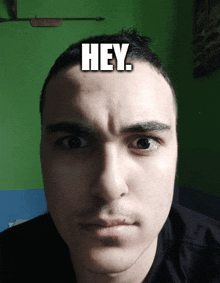 a close up of a man 's face with the word hey written on his forehead .