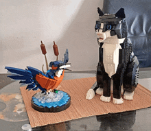 a black and white lego cat standing next to a lego bird statue