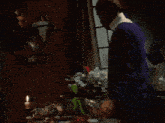 a man in a purple sweater stands in front of a muppet