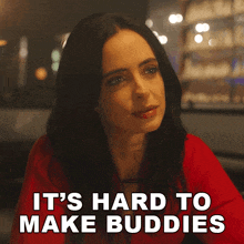 a woman sitting at a table with the words " it 's hard to make buddies " behind her