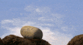 a large rock is sitting on top of a hill