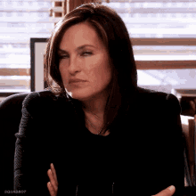 a woman is sitting in a chair and making a funny face .