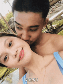 a man kissing a woman on the cheek with missu written on the bottom right