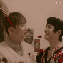 two young men are standing next to each other and one of them is holding a lollipop .