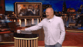a man in a white shirt is standing in front of a podium with a picture on it