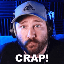 a man with a beard wearing an adidas hat and headphones