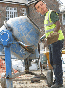 a construction worker is mixing concrete in a mixer