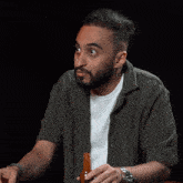 a man with a watch on his wrist is holding a bottle