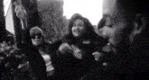 a black and white photo of a group of people with one woman wearing sunglasses