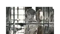 a man with glasses is looking out a window