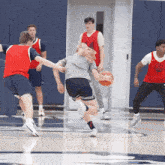 a group of young men are playing a game of basketball and one of them is wearing a nike vest