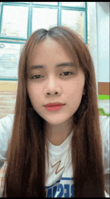 a woman with long brown hair is wearing a white shirt that says 121