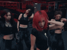 a woman with red hair is wearing a black shirt and necklace