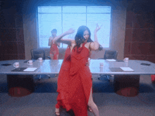 a woman in a red dress is hugging another woman