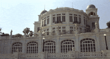 a large white building with a dome on top has a lot of windows