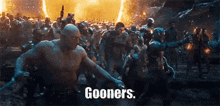 a group of people are standing in front of a fire and the words `` gooser 's '' are written on the bottom .