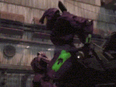a purple robot with a green stripe on its chest