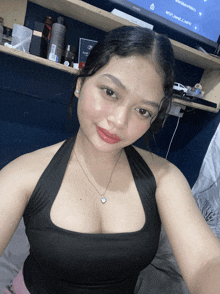 a woman in a black tank top takes a selfie in front of a toshiba tv