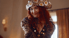 a woman with red hair wearing a hat and a very revealing top
