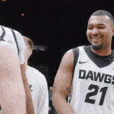 a man in a dawgs 21 jersey smiles