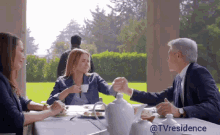 a group of people are sitting at a table with a caption that says tvresidence