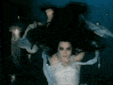 a woman in a white dress is swimming underwater