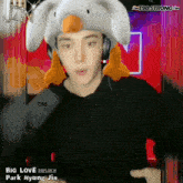 a man wearing a duck hat and headphones says " big love park hyung jin "